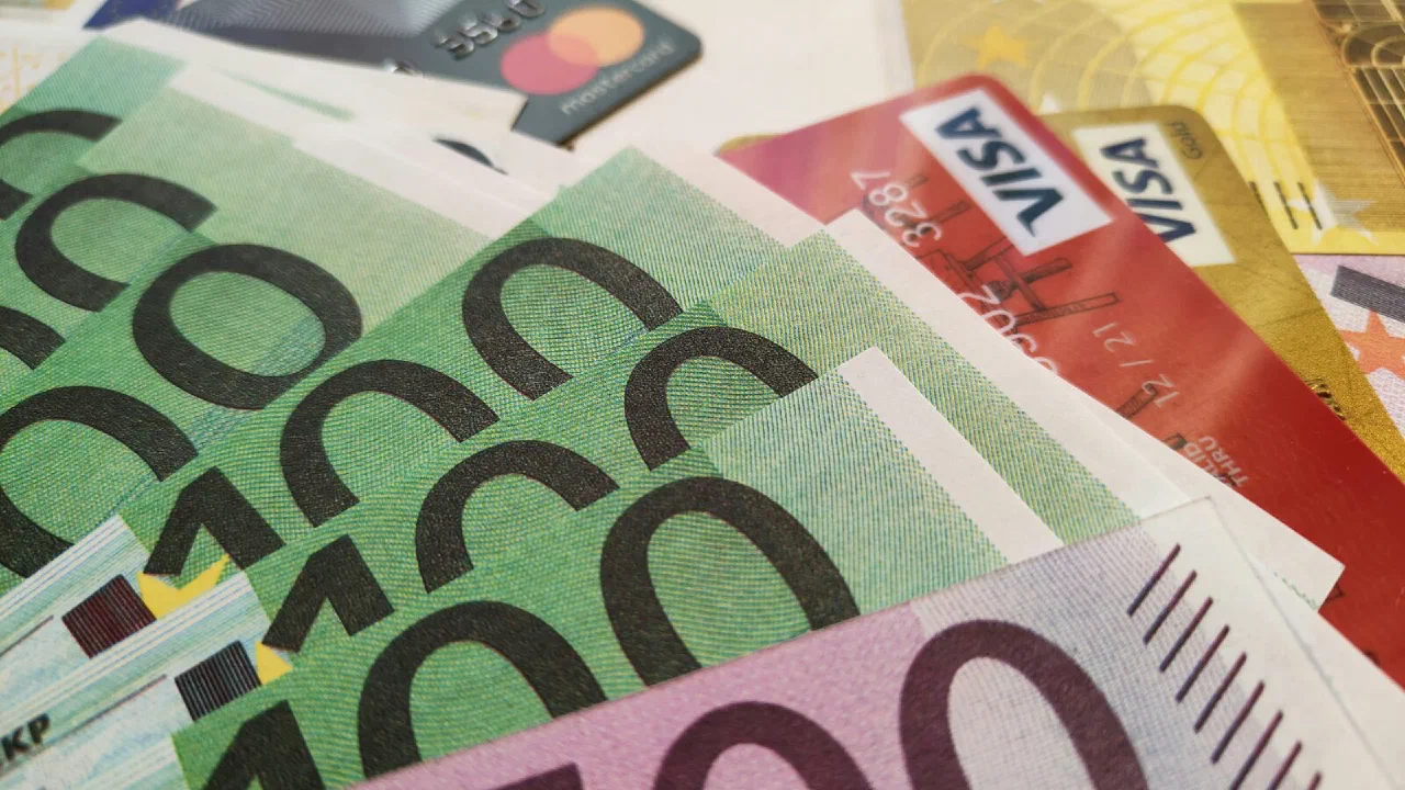 Euro banknotes spread out with a credit card lying among them