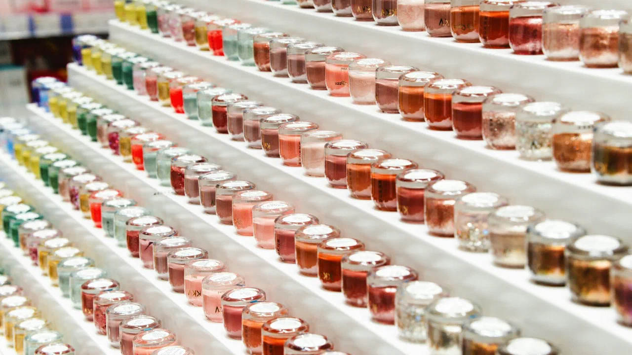 Rows of small glass bottles of coloured liquid on a shop shelf