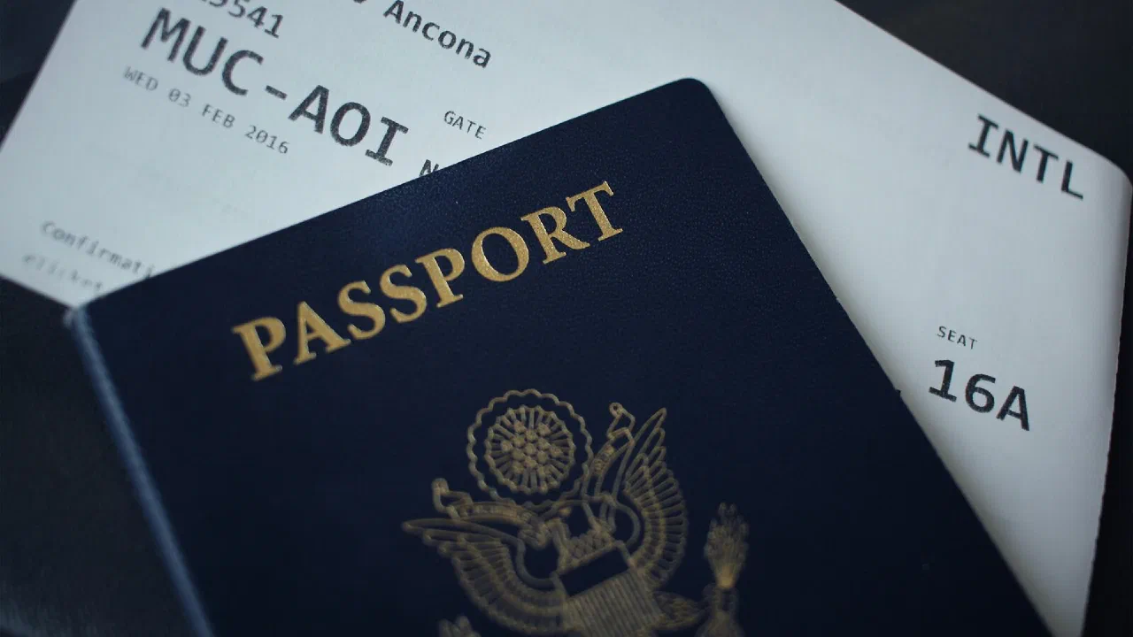 A passport lying on top of a sheet of white paper on a dark surface