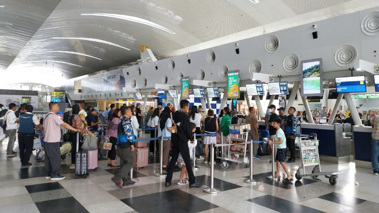 A long queue of travellers waiting at airport check-in counters