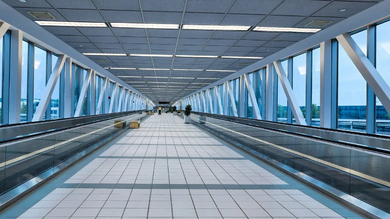 A glass-walled airport walkway with a moving walkway running along it